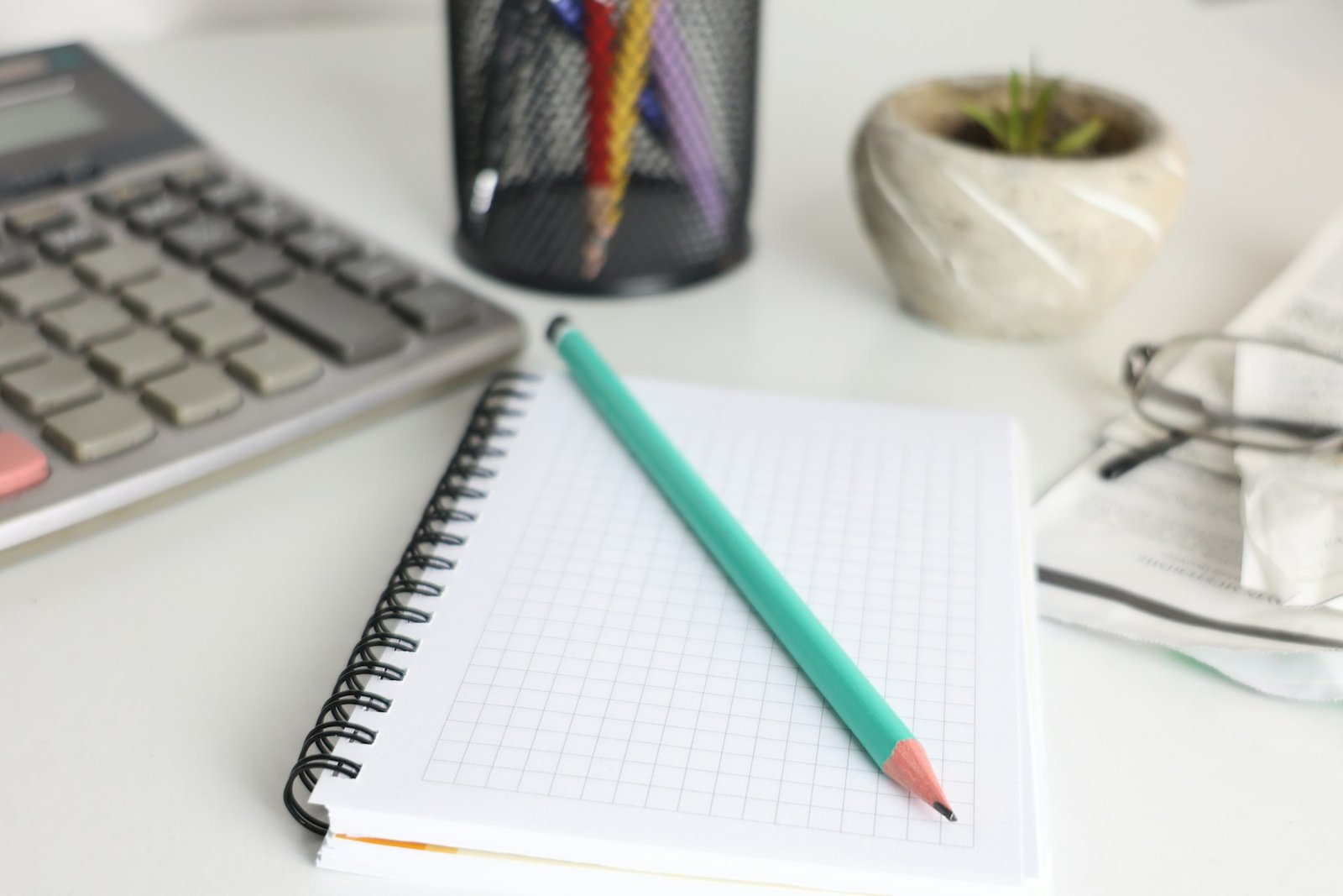 Calculator and notebook on a desk, representing financial planning before investing